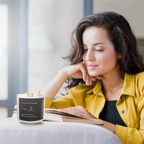 Lifestyle shot of a lit 16oz hand-poured 100% soy candle in a modern living room, with a woman in a yellow shirt reading a book next to the candle. Showcases luxury aromatherapy, essential oils, and a 70-hour burn time.
